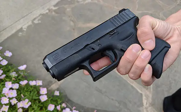 glock 27 in small female hands, extended grip on magazine